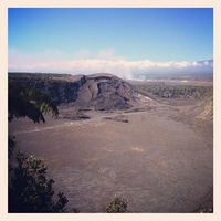 a huge crater and some fumes in the background